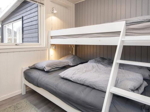 1 dormitorio con litera y escalera en Holiday home Juelsminde LII, en Sønderby
