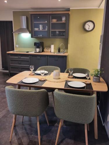 a kitchen with a table with chairs and a clock at Komfort FeWo l Moselstay l maximal 4 Personen und Baby I Brauneberg Mosel I WIFI I in Brauneberg