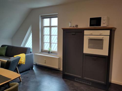 a living room with a couch and an oven at Komfort FeWo l Moselstay l maximal 4 Personen und Baby I Brauneberg Mosel I WIFI I in Brauneberg