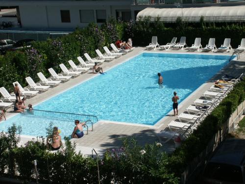 - une piscine avec des chaises et des personnes dans l'eau dans l'établissement COSTA DEL SOL, à Lido di Jesolo