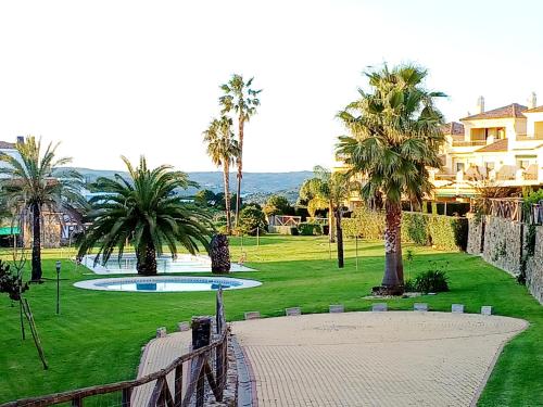 a view of a park with palm trees and a walkway at Vistas al Guadiana, Chalet a 10 minutos de la playa in Ayamonte