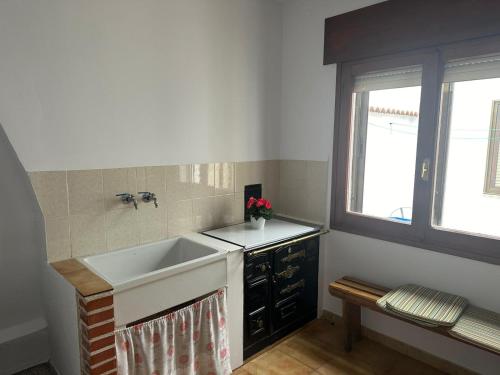 eine Küche mit einem Waschbecken und einem Fenster in der Unterkunft Casa Verilia in Olombrada