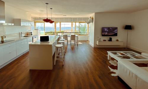 uma grande cozinha com armários brancos e uma sala de estar em Rincón De La Zofra em El Campello