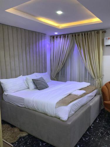 a bedroom with a large bed with drapes at GREEK VIEW APARTMENT VICTORIA ISLAND in Lagos