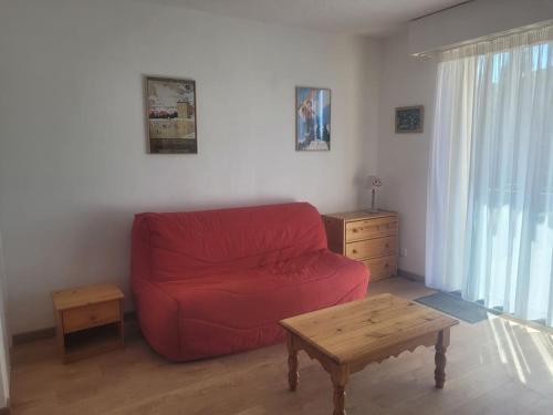 Sala de estar con sofá rojo y mesa de centro en Studio cabine 4 couchages, en Font-Romeu-Odeillo-Via