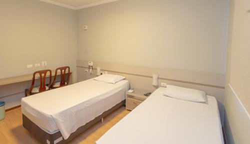 a room with two beds in a room at Lizon Curitiba Hotel in Curitiba