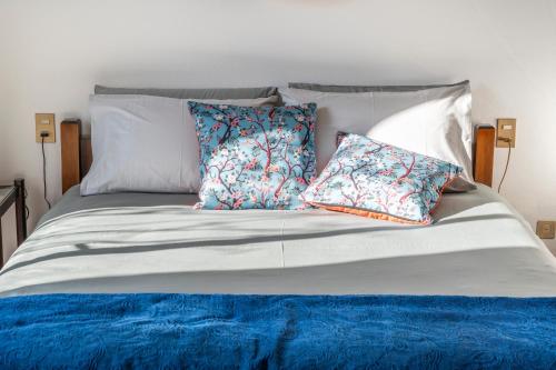 uma cama com lençóis e almofadas azuis e brancos em Luxury Loft em Milão