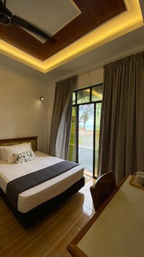 a bedroom with a bed and a large window at Eleven25 Roomstay in Dungun