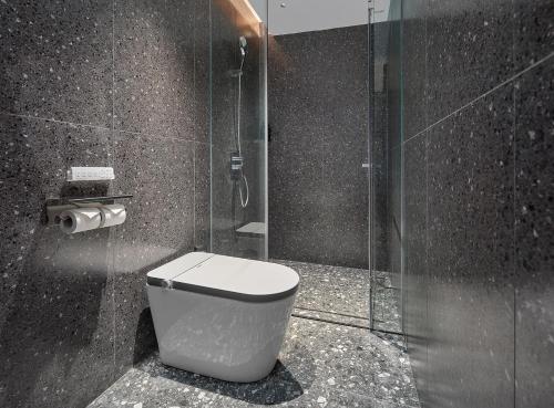 a bathroom with a toilet and a glass shower at Lan Wan Hotel - Next to Huangsha Metro St ation -One cup of Free Cockt ail or Harbin Beer Per Room--Cha rgeable Airport Pick-up Service in Guangzhou