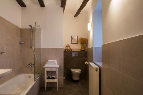 a bathroom with a tub and a toilet and a sink at Casa de la Cadena in Asiáin