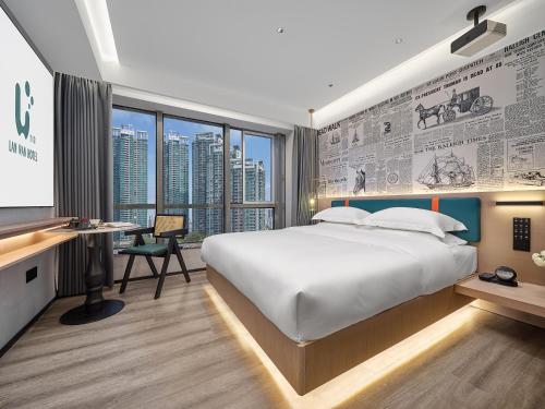 広州市にあるLanwan Hotel - Guangzhou Shamian Island Yongqingfang Branchのベッドルーム1室(大型ベッド1台、モニター付きデスク付)