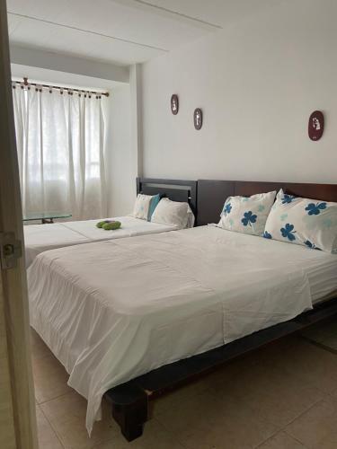 ein Schlafzimmer mit einem großen Bett mit weißer Bettwäsche und Kissen in der Unterkunft apto caney 301 in Cali