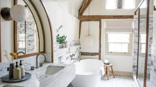 a bathroom with a white tub and a sink at BULL Burford in Burford