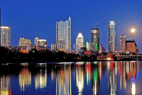 a view of a city skyline at night at Luxe Modern Treehouse w Heated Pool, Firepit in Dripping Springs
