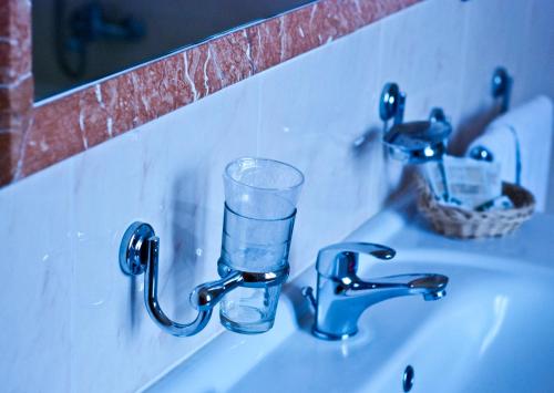 a glass of water sitting on a bathroom sink at Hotel Picchio in Orvieto