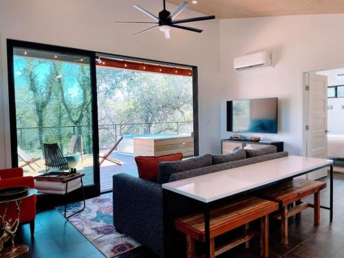 a living room with a couch and a table at Gorgeous Modern Cabin w Heated Pool, Firepit in Dripping Springs