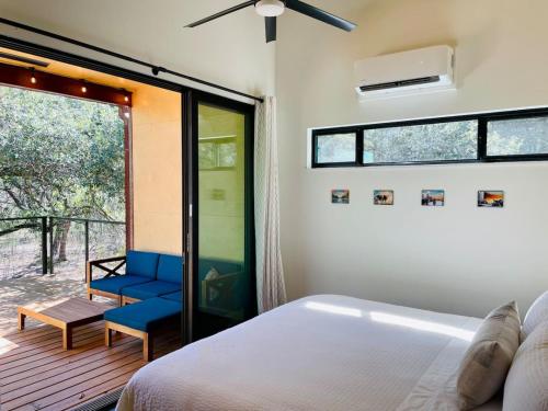 a bedroom with a bed and a sliding glass door at Gorgeous Modern Cabin w Heated Pool, Firepit in Dripping Springs