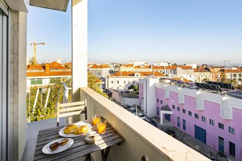 una mesa con platos de comida en la parte superior de un balcón en WHome | 270º Panoramic View Premium Apartment en Lisboa