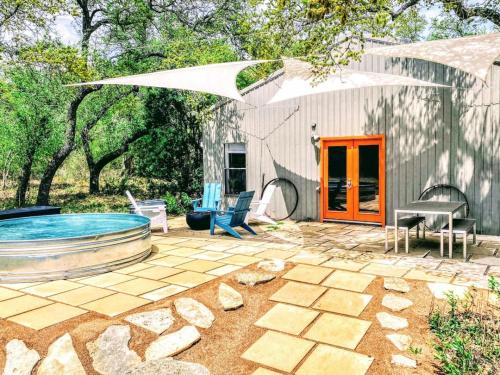 a backyard with a swimming pool and an umbrella at Cozy Cabin w Pvt Heated Pool Under Epic TX Stars in Dripping Springs