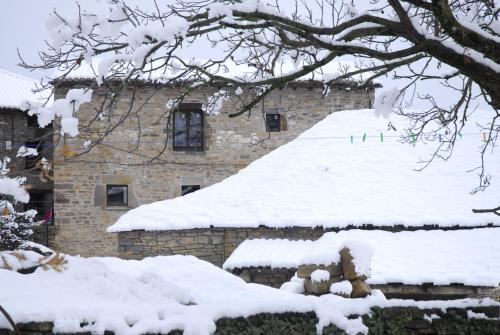 a building with snow on the roof of it at O Chardinet d'a Formiga in Aínsa