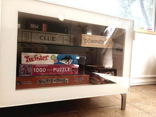 a display cabinet with books and food in it at Cozy Cabin w Pvt Heated Pool Under Epic TX Stars in Dripping Springs
