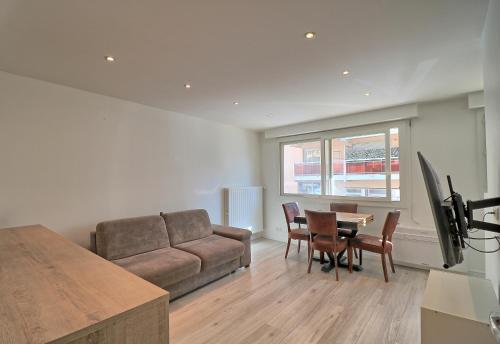 un salon avec un canapé, une table et des chaises dans l'établissement Appartement plein centre proche Palais et plages, à Cannes