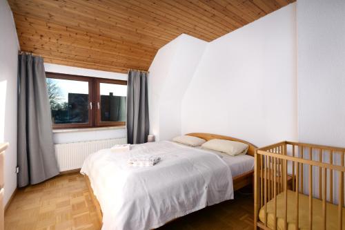 1 dormitorio con cama, ventana y cuna en Wagner´s Residenz, en Heikendorf