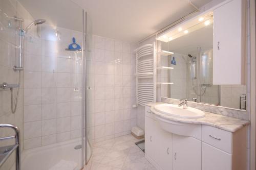y baño blanco con lavabo y ducha. en Wagner´s Residenz, en Heikendorf