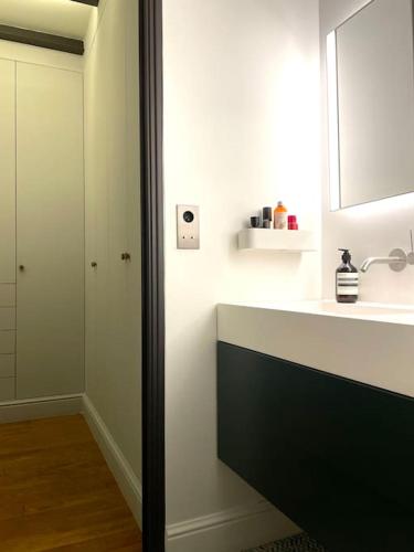 une salle de bain avec un lavabo et un miroir dans l'établissement Golden Braque: luxury meet history, à Paris