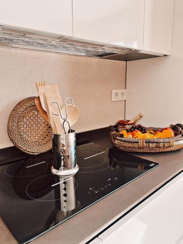 a kitchen counter with a stove with a basket of food at Casa rural el Retiro de Sancho in Cózar