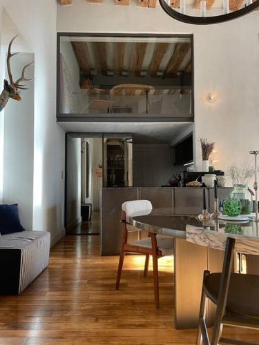 un salon avec une table et une cuisine dans l'établissement Golden Braque: luxury meet history, à Paris