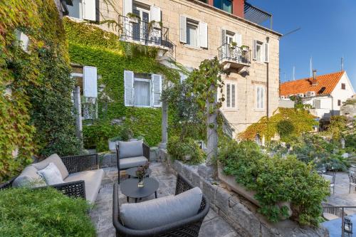 a patio with chairs and a table in front of a building at Hotel San Giorgio in Vis
