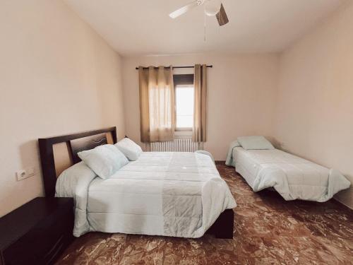 a bedroom with two beds and a window at Casa rural el Retiro de Sancho in Cózar