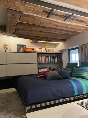 - une chambre avec un grand lit et une étagère dans l'établissement Golden Braque: luxury meet history, à Paris