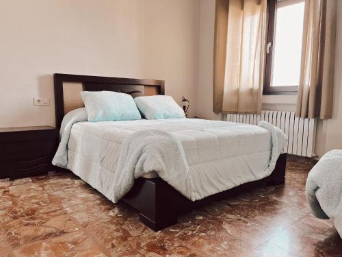 a bedroom with a large bed with blue pillows at Casa rural el Retiro de Sancho in Cózar
