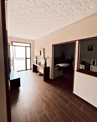 a living room with a ceiling and a room with a table at Casa rural el Retiro de Sancho in Cózar