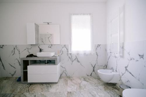 a white bathroom with a sink and a toilet at Residenza La Boheme in Verona
