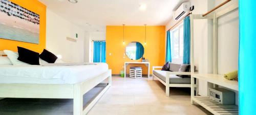 a bedroom with a bed and a couch in it at Blue Mango Beach Hotel in Guachaca