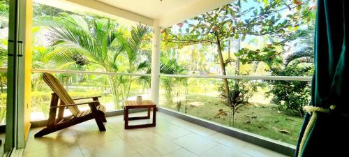 a room with a large window with a chair in front of it at Blue Mango Beach Hotel in Guachaca
