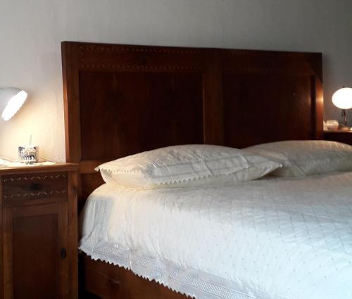 a bed with a wooden headboard next to a night stand at Antica Dimora Russit in Mediis