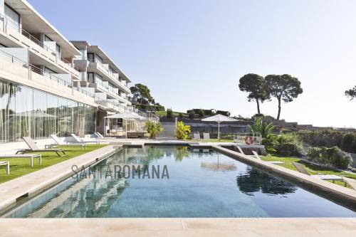 uma imagem de uma piscina em frente a um edifício em Santa Romana Apartments & Suites em Caldes d'Estrac