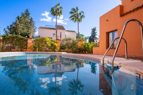 - une piscine en face d'un bâtiment avec des palmiers dans l'établissement Beachside Newly Renovated Apartments - Globales, à Estepona