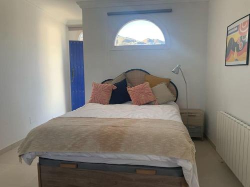 a bedroom with a large bed with a window at Villa Casa Queen in Mojácar