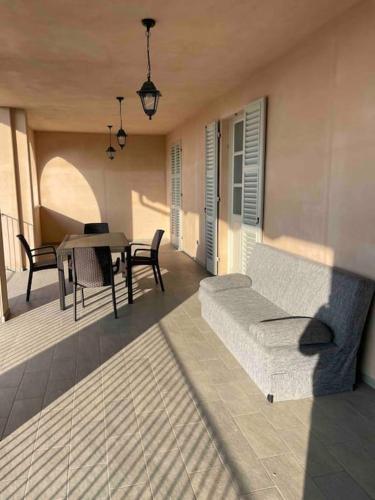 patio z łóżkiem, stołem i krzesłami w obiekcie Appartamento Mary w mieście Cherasco