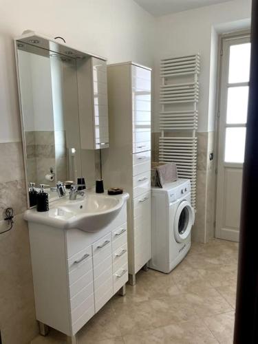 łazienka z umywalką i pralką w obiekcie Appartamento Mary w mieście Cherasco