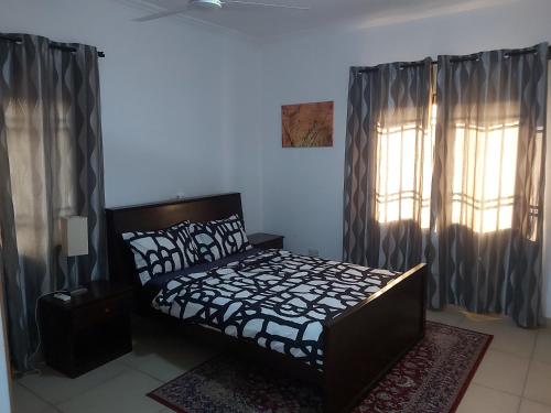 a bedroom with a bed and a window with curtains at RESIDENCE IVOIRE in Accra