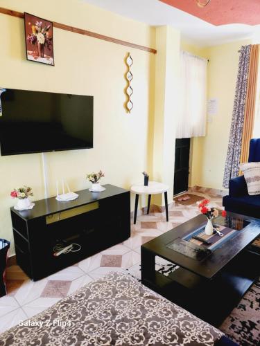 un soggiorno con una grande TV a schermo piatto di Cosy 1 Bedroom TRM,Thika Rd a Nairobi