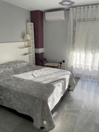 een slaapkamer met een bed met een deken erop bij Adosado Riviera Del Sol in Sitio de Calahonda