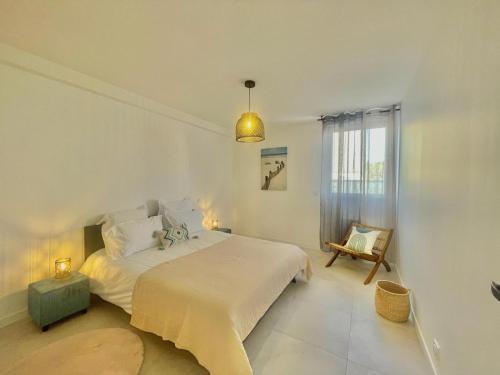 une chambre blanche avec un lit et une fenêtre dans l'établissement APPART'ICI 3 - Spacieux appartement F3, à Lunel-Viel