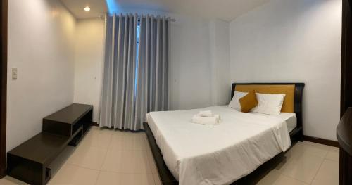 a bedroom with a bed with white sheets and pillows at SOCHU HOUSE- Tuần Châu Homestay & Coffee in Ha Long